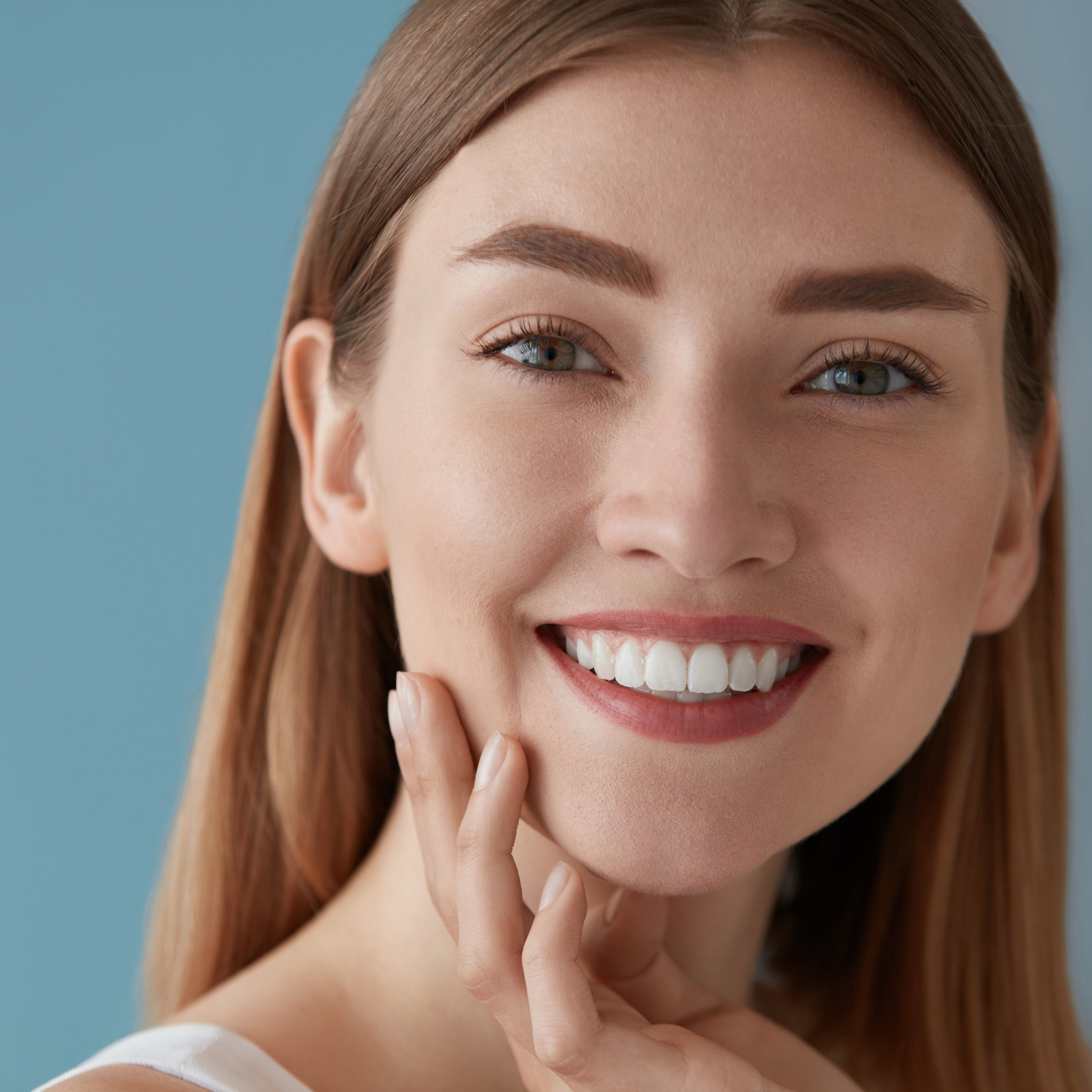 Beauty portrait of smiling woman with white teeth smile. Beautiful happy girl with fresh skin, natural face makeup indoors closeup